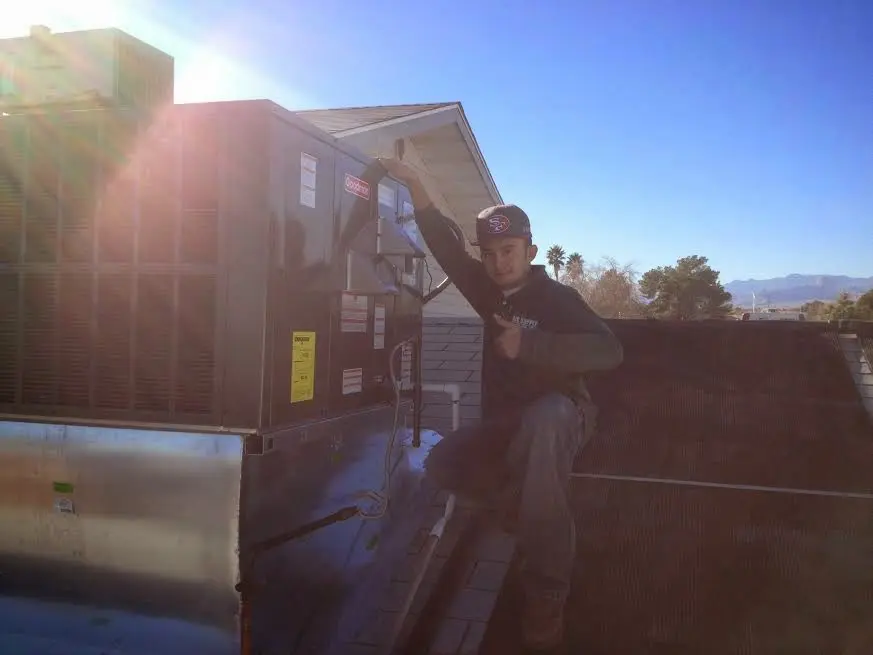 HVAC technician performing HVAC Inspection on a rooftop unit in Norwalk